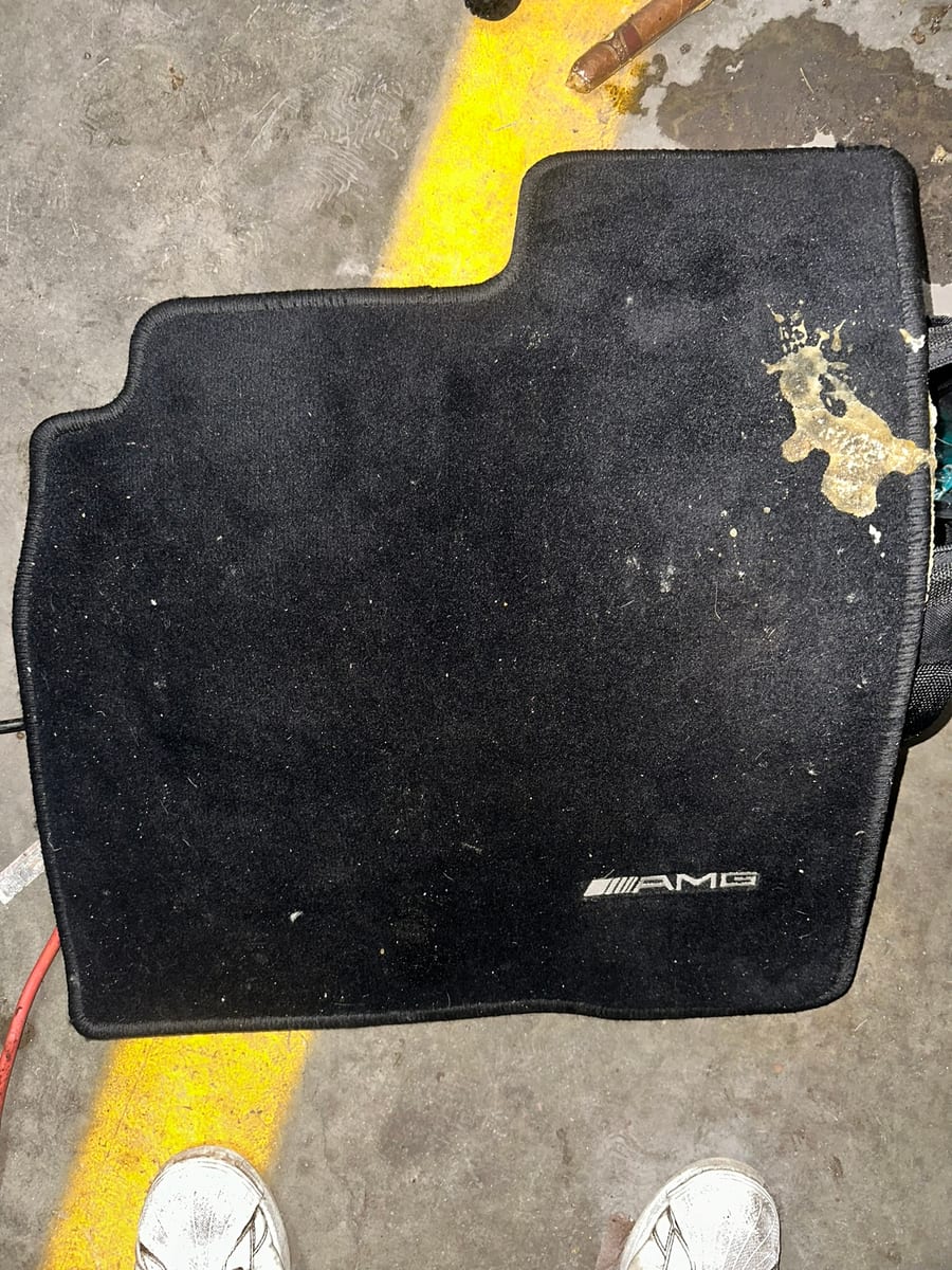 Mercedes AMG floor mat with heavy staining before extraction